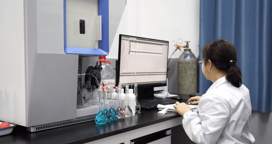 Laboratory technician performing analysis with lab glassware and instruments.